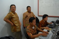 Vier mannen dragen een batikoverhemd op kantoor.