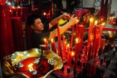 Een Chinees-Indonesische man brandt kaarsjes voor het Chinees nieuwjaar in Pontianak (West-Kalimantan).