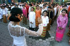 Opgemaakte schoolmeisjes zingen een liedje op Kartinidag.