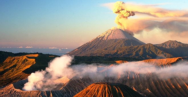 Zowel de Semeru (achter) als de Bromo (linksvoor) spuwen rook uit tijdens de zonsopkomst.